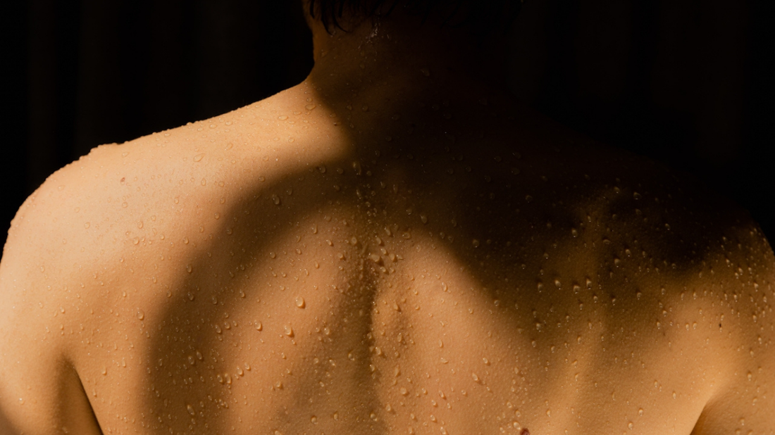 Close-up of a human back with water droplets.