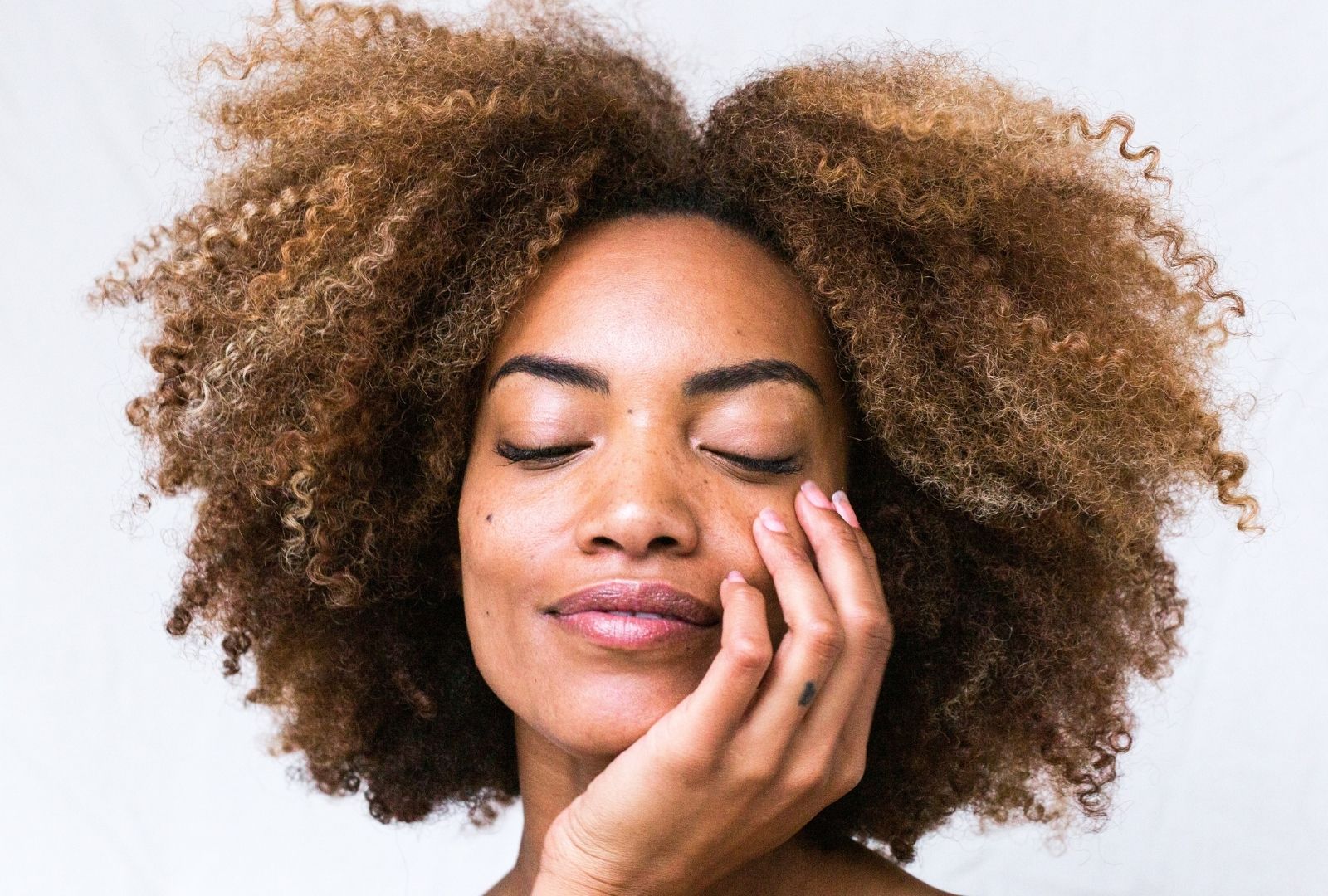 Fuzzy haired woman wears no makeup beauty trend