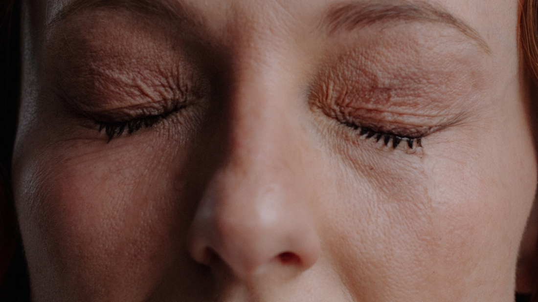 Close-up of a woman’s face with eyes closed.