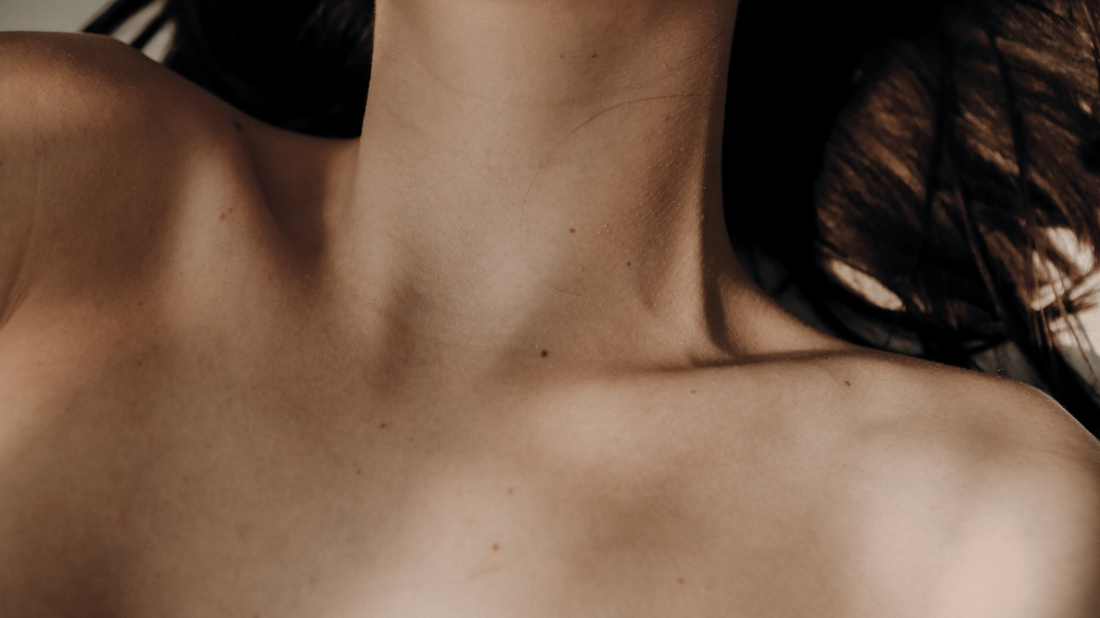 Softly lit collarbone and neckline, highlighting radiant, healthy skin.