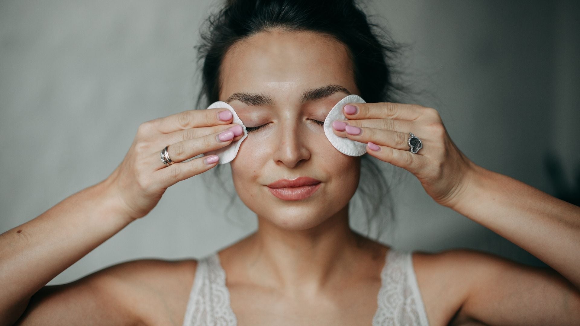 Woman using cotton pads to remover her makeup