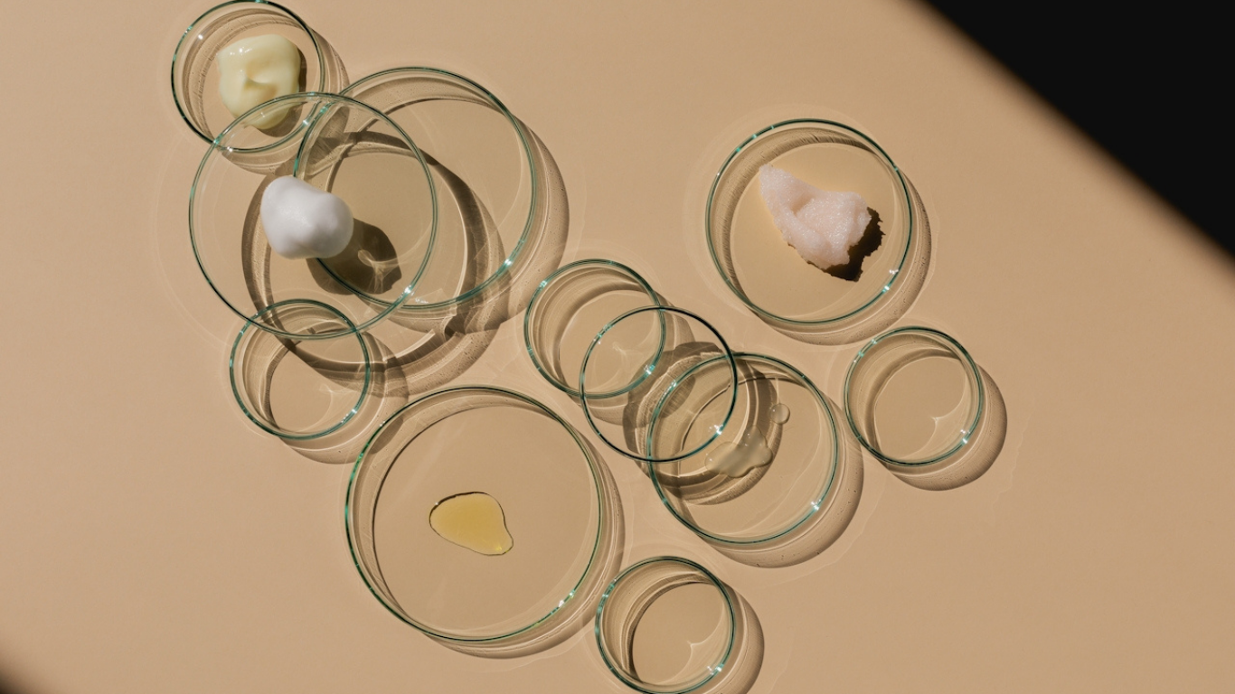 Glass petri dishes with skincare textures and oils