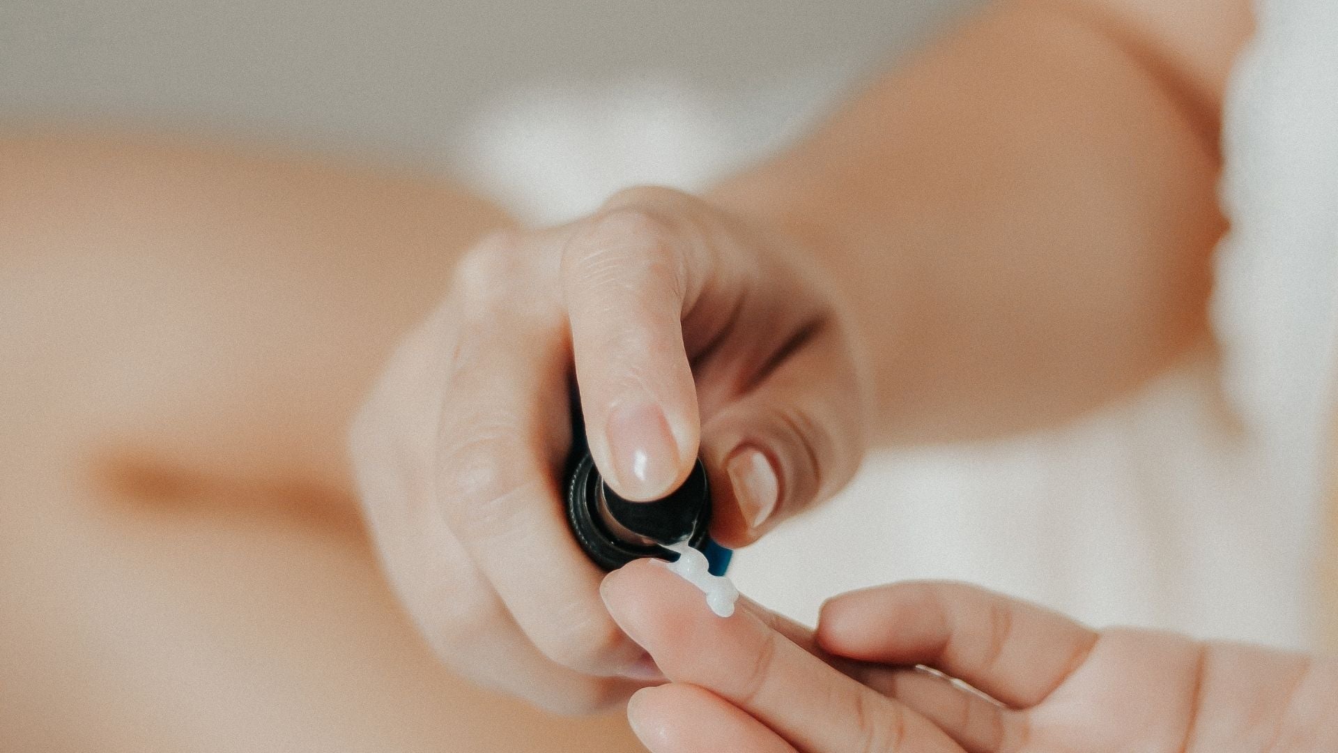 Woman's hands applying skincare products